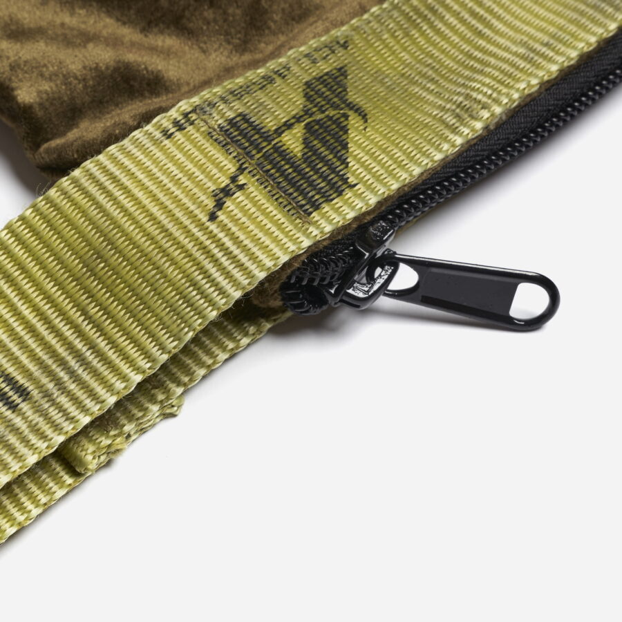 A vintage velour fabric sling pouch with recycled belt and zip closure.